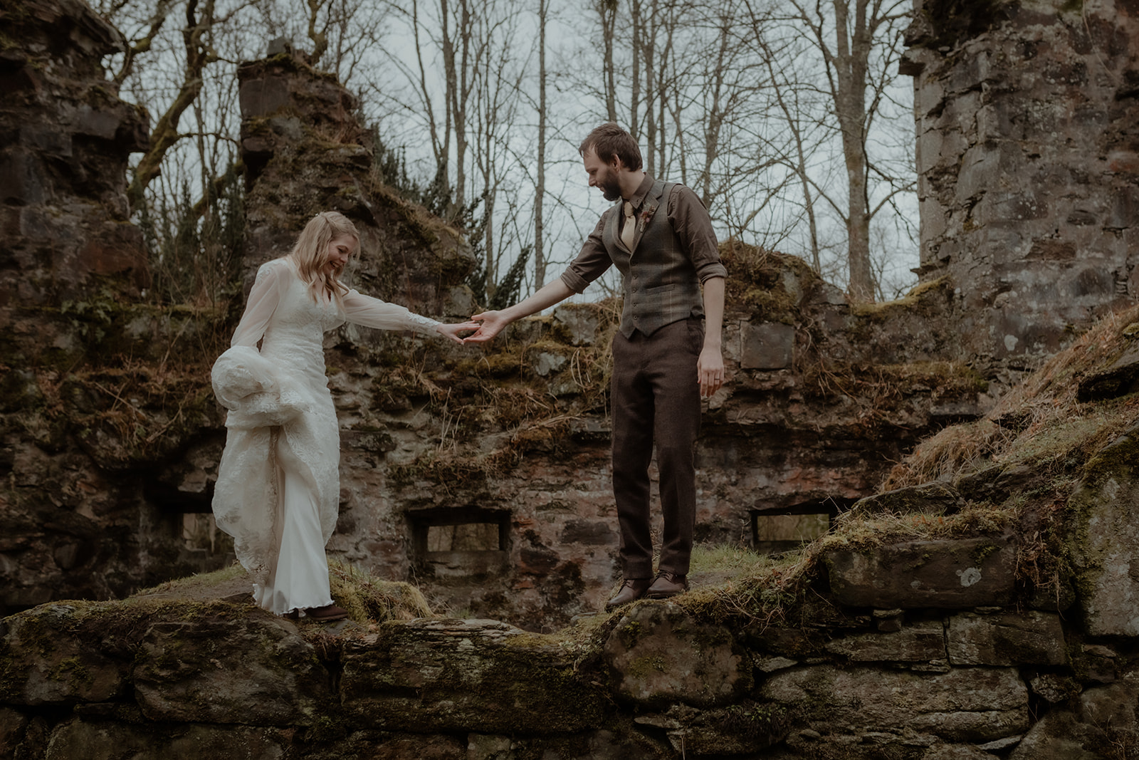Intimate Scotland elopement at historic stone ruins, with a couple walking hand in hand capture by Scotland elopement photogrpaher