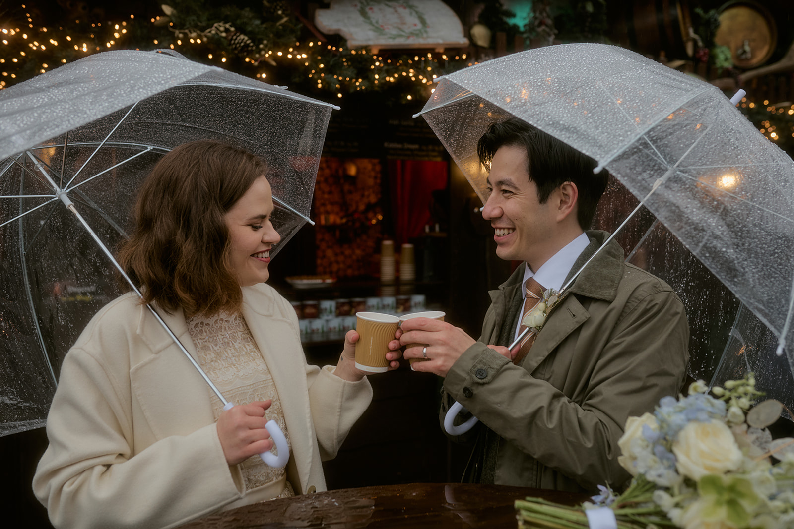 Couple enjoying mulled wine at Edinburgh Christmas Market during their elopement.