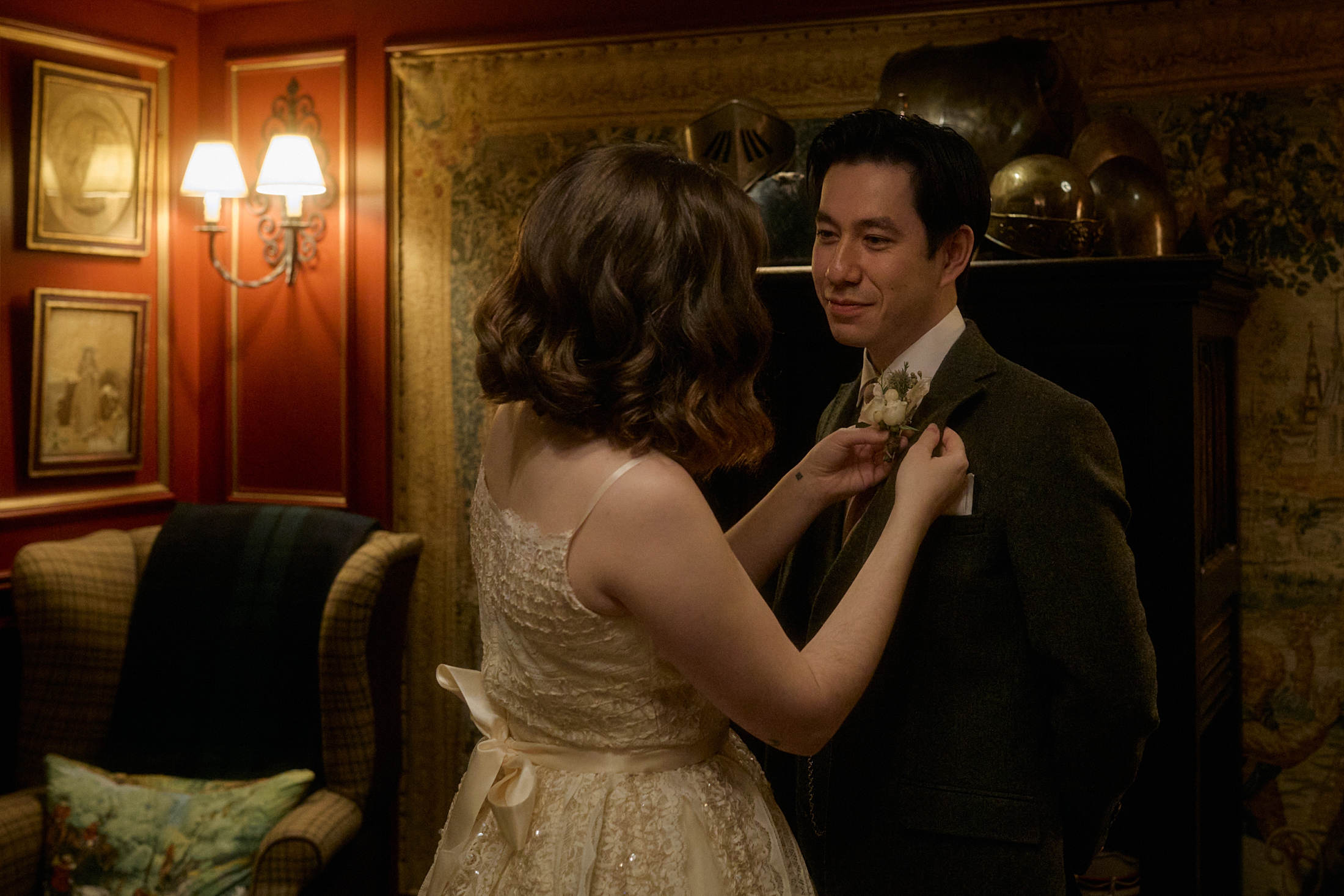 Bride adjusting boutonniere at The Witchery in Edinburgh before the ceremony