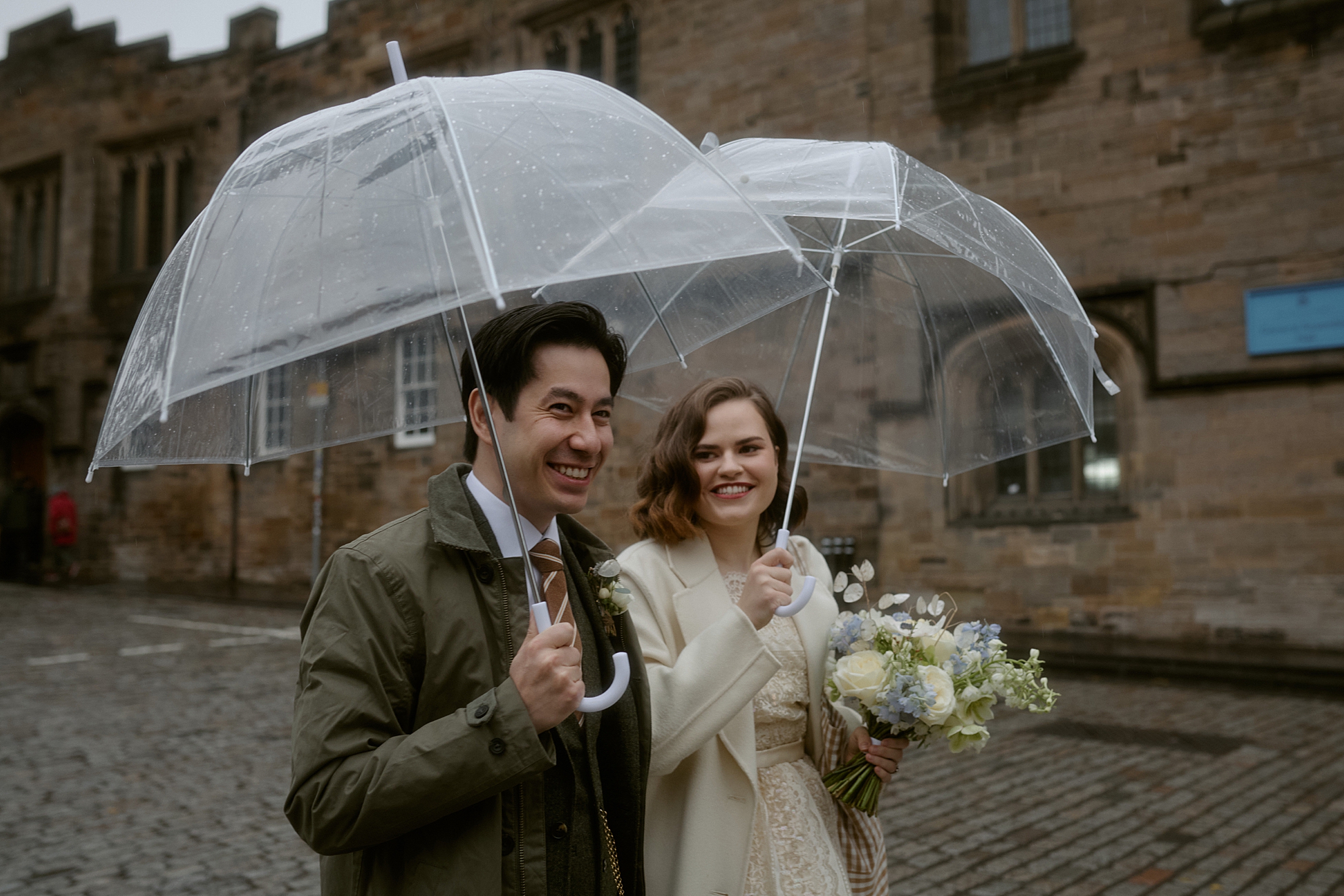 Couple walking through Edinburgh Old Town with umbrellas on the way to Riddle’s Court