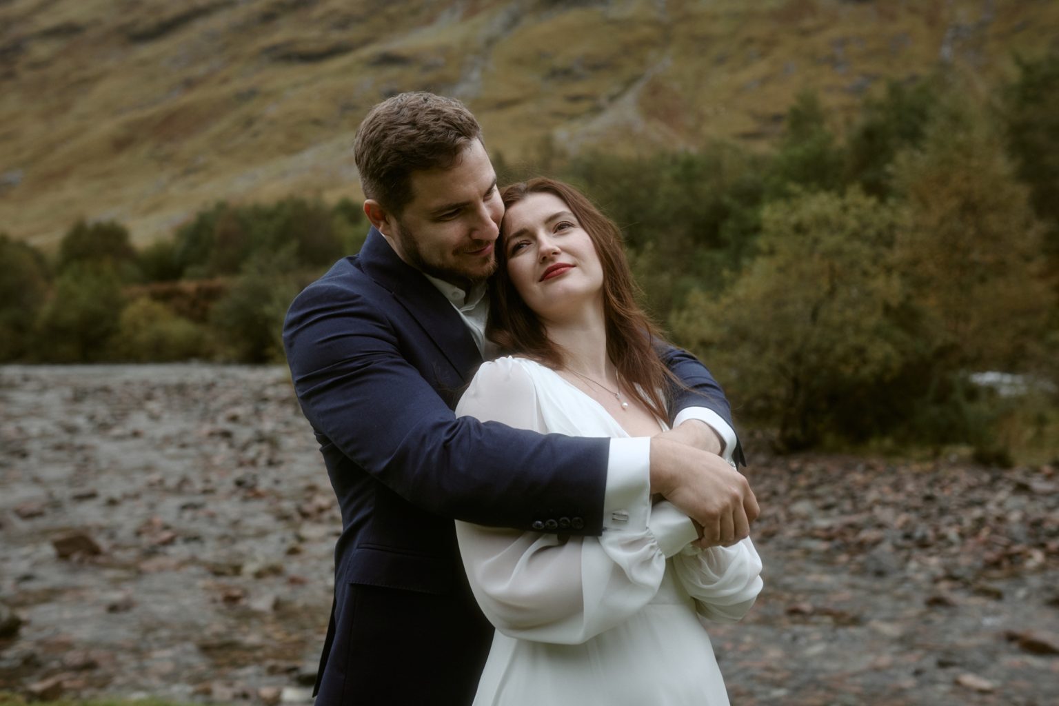 Couple embracing in Glencoe valley during intimate Scotland elopement