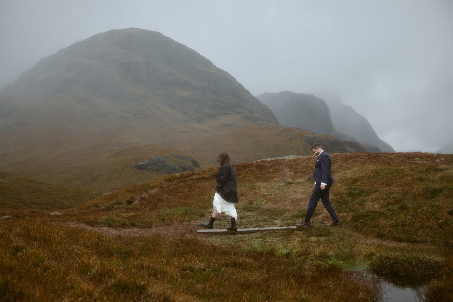 Couple walking through misty Glencoe during elopement in Scotland